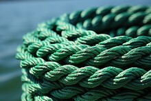 Detailed View Of A Vibrant Green Rope Against A Backdrop Of Water