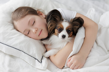 Wall Mural - little girl sleeping in bed with her cute dog under blanket