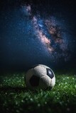 Fototapeta Sport - Soccer ball on grass under the night sky, illuminated by spotlight.