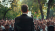 Man politician giving a speech outdoors in front of a crowd of members of a political party