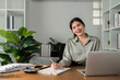 © itchaznong - business finance woman sitting at a desk with laptop and document financial clipboard