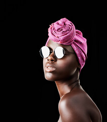 Wall Mural - Face, fashion and shades with African woman in studio isolated on black background for heritage. Beauty, model and sunglasses with confident young person in trendy headwear for traditional style