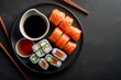 Sushi set on wooden board with chopsticks and soy sauce. Top view