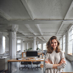 Wall Mural - Portrait of a smiling young woman looking at the camera with her arms crossed. Good girl standing in a creative office.