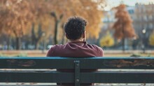 Man Sits On A Bench In A Fall Park