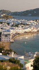 Wall Mural - View of Mykonos town with famous windmills, and port with boats and yachts on summer sunset. Mykonos, Cyclades islands, Greece. With camera panning