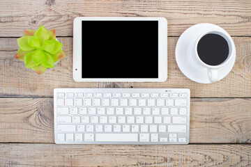 Wooden office table with computer, pen and a cup of coffee, lot of things. Top view with copy space.