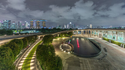 Wall Mural - Aerial view Singapore city skyline with colorful fountain at Marina barrage garden night timelapse.