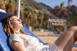 Young woman sunbathing on beach, sun protection concept