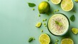 A vibrant green smoothie surrounded by fresh limes and fragrant mints