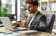 © Raptecstudio - Man in suit with credit card using computer on desk