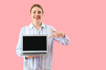 Poster - Female programmer pointing at blank laptop on pink background