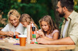 © Zamrznuti tonovi - A happy family is playing wooden tile game and competing.