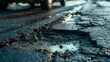 Damaged asphalt road surface with pothole. Close-up shot of a pothole on a weathered, cracked asphalt road with vehicles in the background