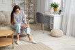 © Pixel-Shot - Young woman suffering from knee pain at home