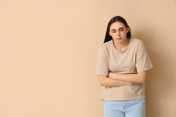 Poster - Young woman suffering from bellyache on beige background