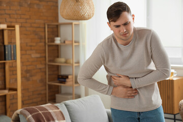 Poster - Young man suffering from bellyache at home