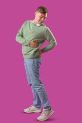 Sticker - Young man suffering from back pain on purple background