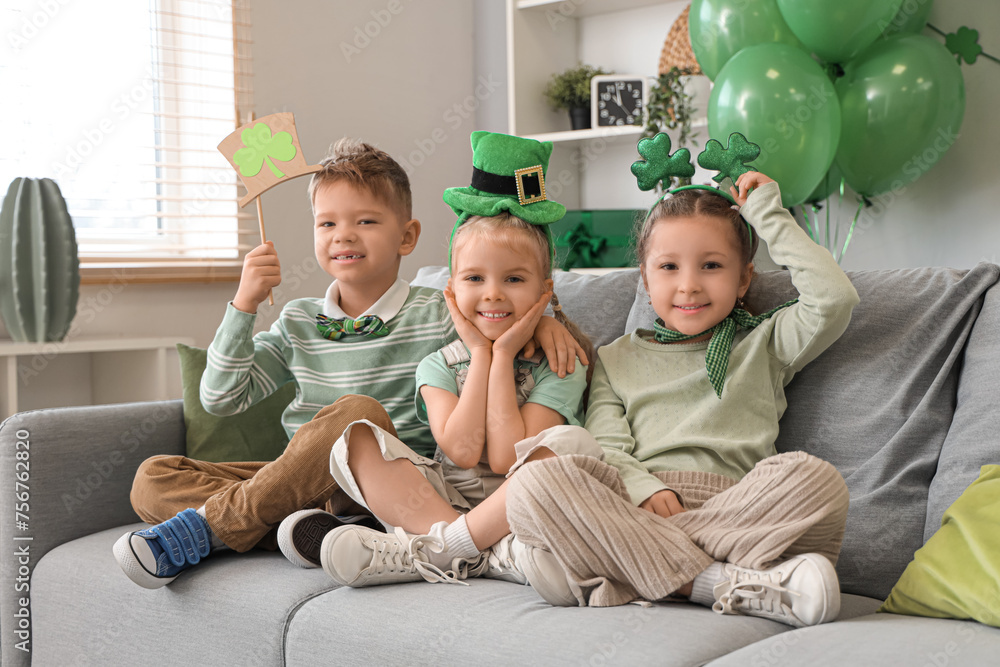 Cute kids celebrating St. Patrick's Day with festive green outfits at home party
