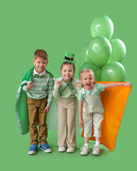 Wall Mural - Cute kids with balloons and flag of Ireland on green background. St. Patrick's Day celebration