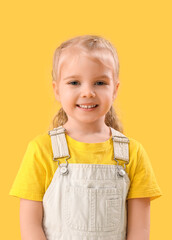 Wall Mural - Portrait of cute little girl on yellow background. St. Patrick's Day celebration