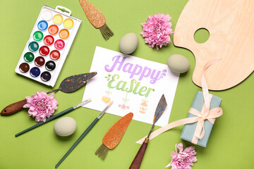 Sticker - Composition with greeting card, painter's tools and Easter eggs on green background