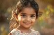 Smiling Indian girl looking at the camera in sunlight.
