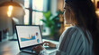 © Nemanja - Closeup of the beautiful young businesswoman sitting in office, and looking at the company charts and graphs, corporate analytics on a laptop or notebook screen. Female employee working, job workplace