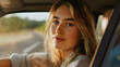 © Nemanja - Closeup of the beautiful young woman with blonde hair driving a car on the road, sitting in the automobile interior, looking at the camera and smiling. Vehicle travel and transport, summer trip