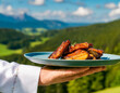 Waiter or chef holding a tray with grilled meat or fried ribs on a beautiful background.