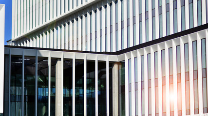 Wall Mural - Modern office building in the city with windows and steel and aluminum panels wall. Contemporary commercial architecture, vertical converging geometric lines.