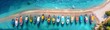 Aerial view of colorful ships parked on the beach lined up in neat rows. On the surface of the clear azure sea water, on the Mediterranean sea. View from a drone