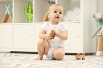 Poster - Children toys. Cute little boy playing with wooden car on rug at home