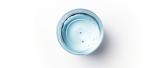 Wall Mural - A closeup shot of a transparent plastic drinkware in electric blue color, filled with liquid on a white background. The circle shape reflects like automotive lighting, resembling a fashion accessory