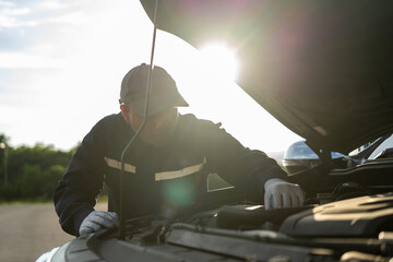 Professional car mechanic maintenance vehicle. The mechanic opens the front of the car. Checking the broken engine. Check the damage as listed. Repair car outside service.