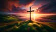 A cross standing on a hill overlooking a body of water with a sunset in the background.