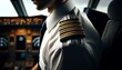 A close-up of a pilot's epaulettes and uniform, showing the stripes indicative of their rank, while sitting in the pilot seat.