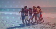 Group of young adults walking together on a beach