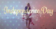 © vectorfusionart - Young Caucasian woman wrapped in an American flag on a beach