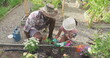 Image of heart flowers over african american father and daughter gardening plants