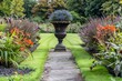Formal garden with flowerbeds grass pathway and ornamental vase