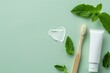 Toothbrush toothpaste tube mint leaves on light green background Heart shape with toothpaste Overhead view blank space