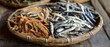 Various types of dried anchovies served on a wooden plate