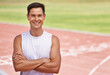 © Duncan M/peopleimages.com - Athlete, portrait or positive for fitness on stadium, arms crossed or commitment to wellness as running professional. American, man or face for confident in sport, outdoor or training for health body