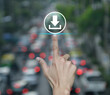 © grapestock - Hand pressing download flat icon over blur of rush hour with cars and road in city, Technology internet online concept