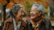 © SashaMagic - Two joyful elderly Asian individuals sitting together.
