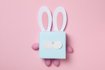 Wall Mural - Blue gift box with rabbit ears on pink background