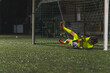 © PoppyPix - full shot of a girl goalkeeper in yellow uniform catching a ball with hands at a match, girlssoccer team. High quality photo