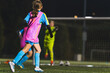 © PoppyPix - back view of little girls with uniforms playing soccer on the stadium, school soccer team. High quality photo