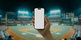 Fototapeta  - A hand holds a smartphone with a green screen at a baseball stadium